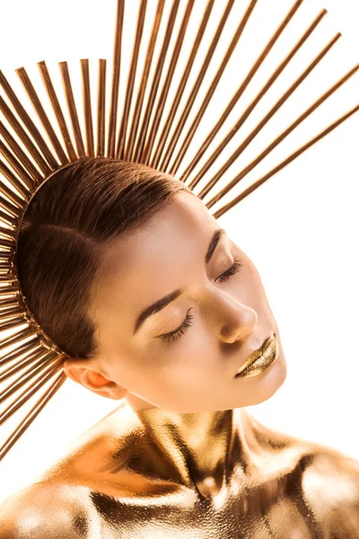 Jeune femme nue peinte en or avec accessoire sur la tête et les yeux fermés isolés sur blanc — Photo de stock