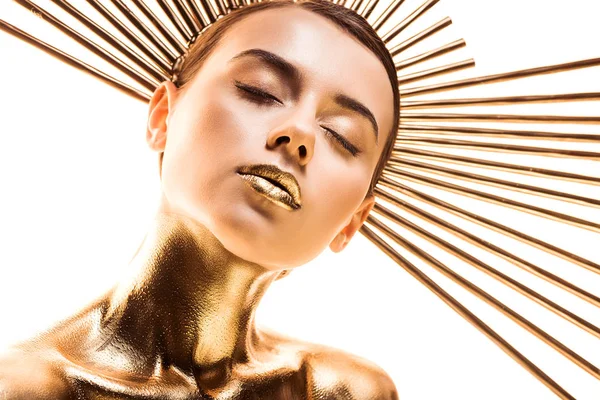 Naked beautiful young woman painted in golden with accessory on head and closed eyes isolated on white — Stock Photo