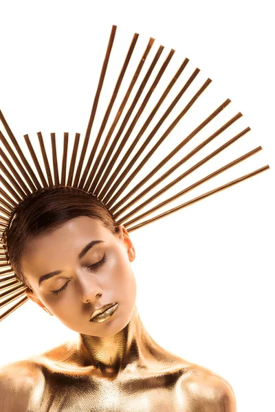 Оголена молода жінка пофарбована в золотий колір з великим аксесуаром на голові і закритими очима ізольовані на білому — стокове фото