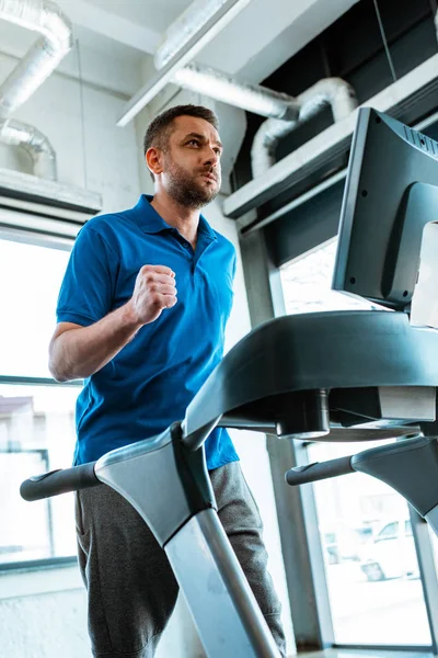 Hombre guapo haciendo ejercicio en la cinta de correr en el gimnasio - foto de stock