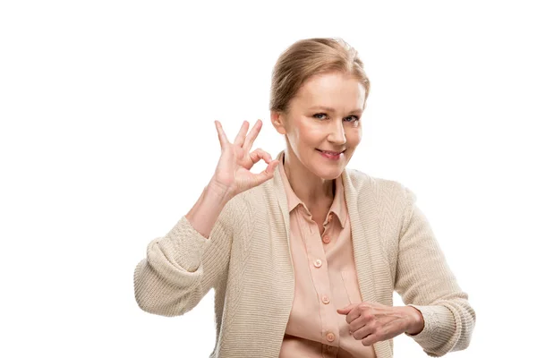 Sorrindo mulher de meia-idade mostrando ok sinal isolado em branco — Fotografia de Stock