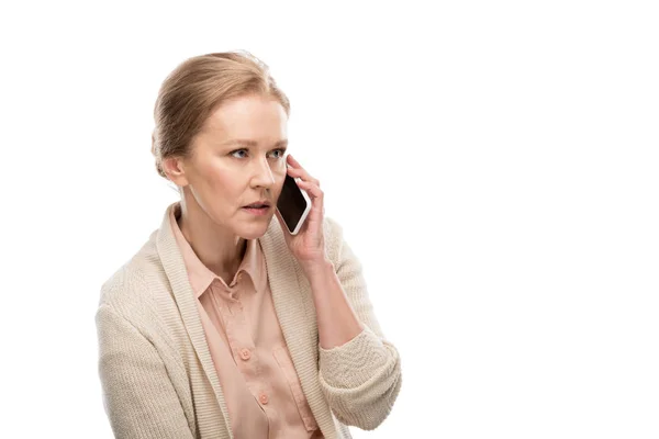 Концентрована жінка середнього віку розмовляє на смартфоні Ізольовані на білому — стокове фото