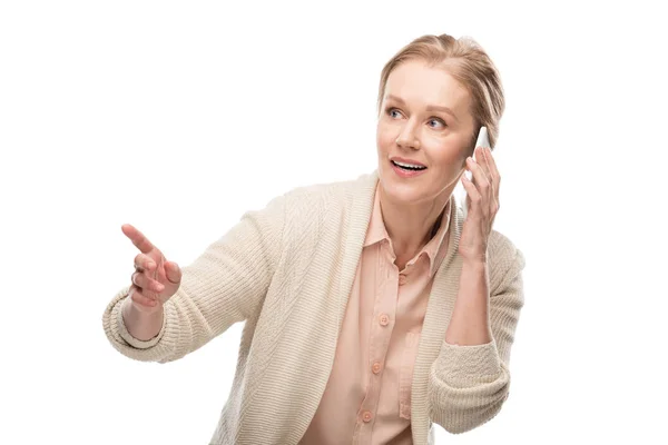 Frau mittleren Alters spricht auf Smartphone und zeigt mit dem Finger isoliert auf weiß — Stockfoto