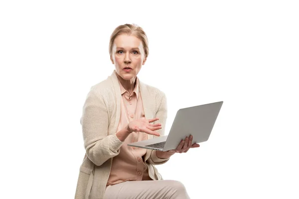 Confuso donna di mezza età utilizzando laptop e gesturing isolato su bianco — Foto stock