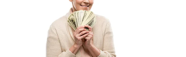 Панорамный снимок улыбающейся женщины средних лет с долларовыми купюрами, изолированными на белом — стоковое фото