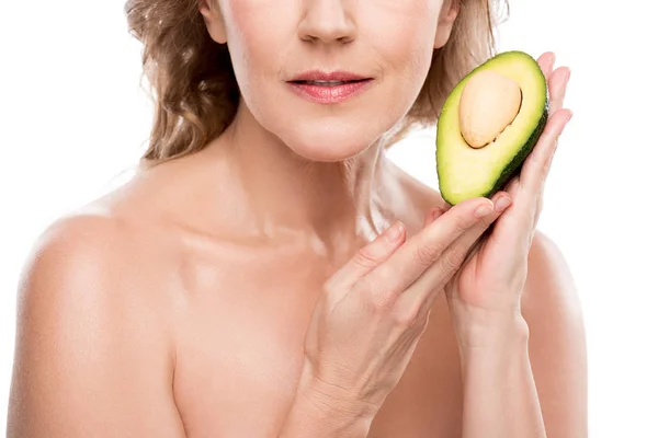 Vista ritagliata di nudo donna di mezza età in posa con avocado isolato su bianco — Foto stock
