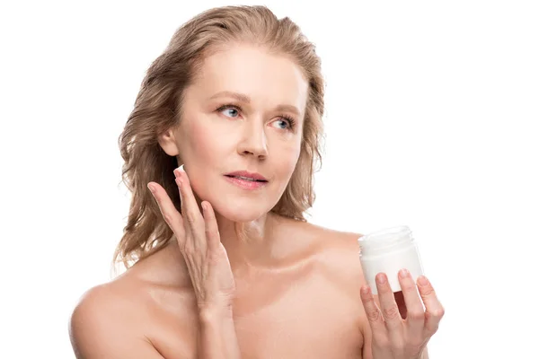 Belle femme mature avec une peau parfaite appliquer la crème cosmétique isolé sur blanc — Photo de stock