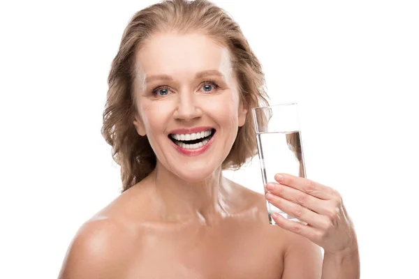 Sorrindo mulher madura com vidro de água olhando para a câmera Isolado em branco — Fotografia de Stock