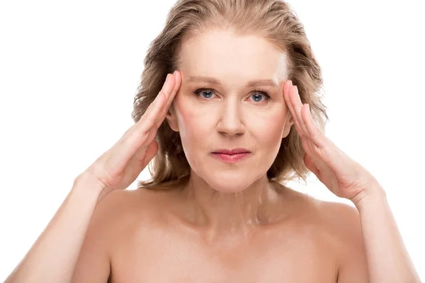 Hermosa mujer de mediana edad con la piel perfecta tocando la cara aislado en blanco - foto de stock