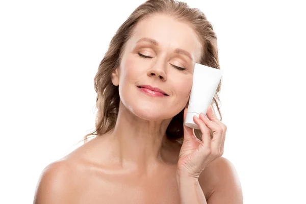 Attraktive reife Frau mit perfekter Haut hält feuchtigkeitsspendende Gesichtscreme isoliert auf weiß — Stockfoto