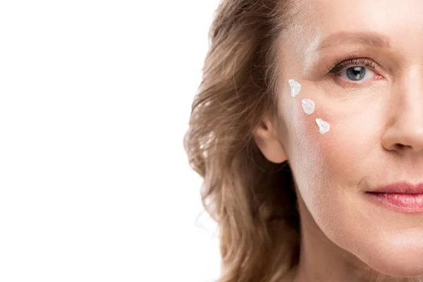 Donna matura con crema cosmetica sul viso isolato su bianco con spazio copia — Foto stock