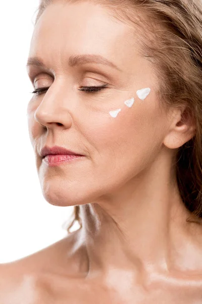 Femme mature avec crème cosmétique sur le visage isolé sur blanc — Photo de stock