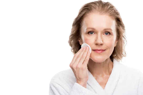 Mature woman wiping face with cotton pad Isolated On White with copy space — Stock Photo