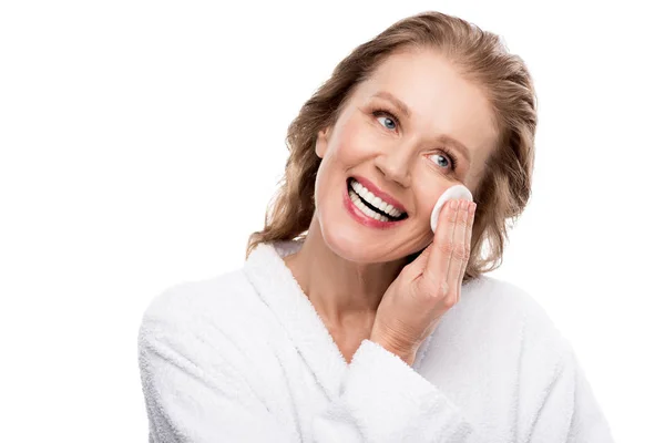 Schöne reife Frau wischt Gesicht mit Wattepad isoliert auf weiß — Stockfoto