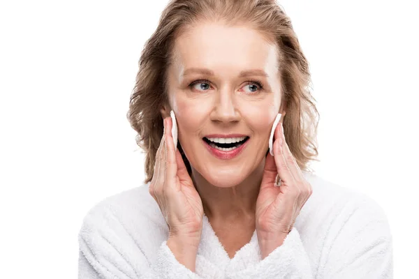 Smiling mature woman wiping face with cotton pads Isolated On White — Stock Photo