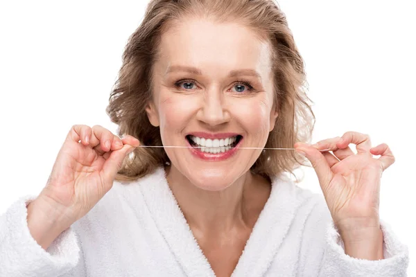 Mujer de mediana edad usando hilo dental aislado en blanco - foto de stock