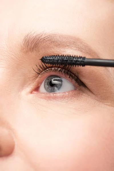 Close up of mature woman applying mascara Isolated On White — Stock Photo
