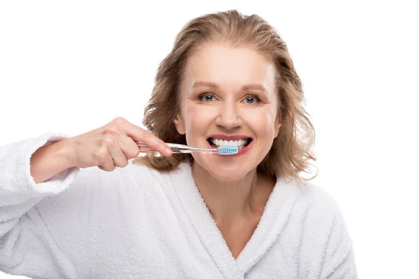 Mujer de mediana edad cepillado dientes aislados en blanco - foto de stock