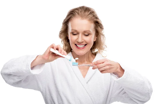 Donna di mezza età con spazzolino e dentifricio isolato su bianco — Foto stock