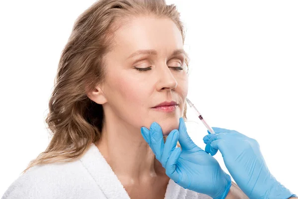 Médico dando inyección de belleza a la mujer de mediana edad aislado en blanco - foto de stock