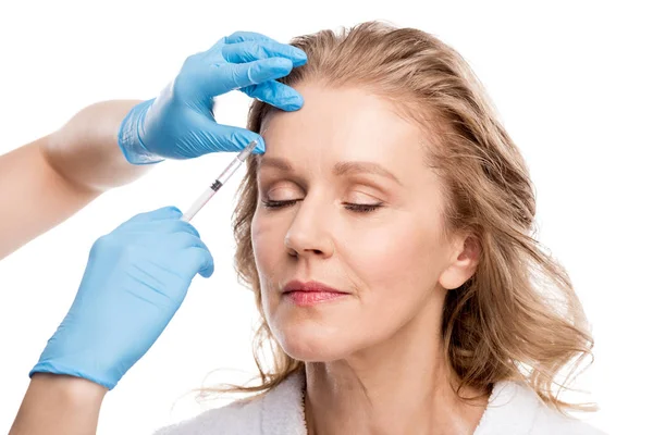 Doctor giving beauty injection to beautiful middle aged woman Isolated On White — Stock Photo