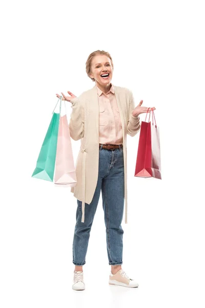 Sonriente mujer de mediana edad con bolsas de compras aisladas en blanco - foto de stock
