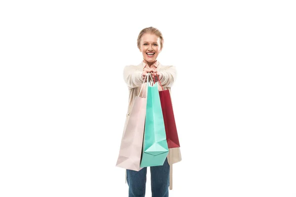 Sorridente donna di mezza età con borse della spesa isolato su bianco con spazio copia — Foto stock