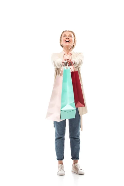 Feliz mujer de mediana edad con bolsas de compras en blanco - foto de stock