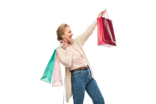 Возбужденная женщина средних лет с пакетами для покупок изолированы на белом — стоковое фото