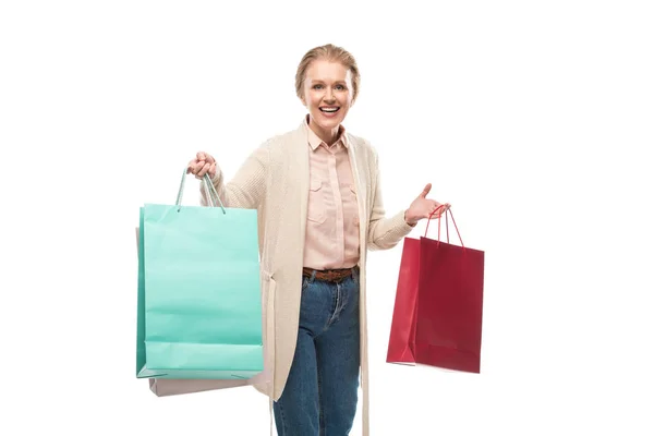 Счастливая женщина средних лет с сумками для покупок, глядя на камеру, изолированную на белом — стоковое фото