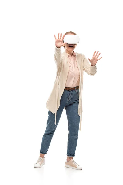 Mujer emocionada en vr gestos auriculares mientras experimenta realidad virtual aislado en blanco - foto de stock