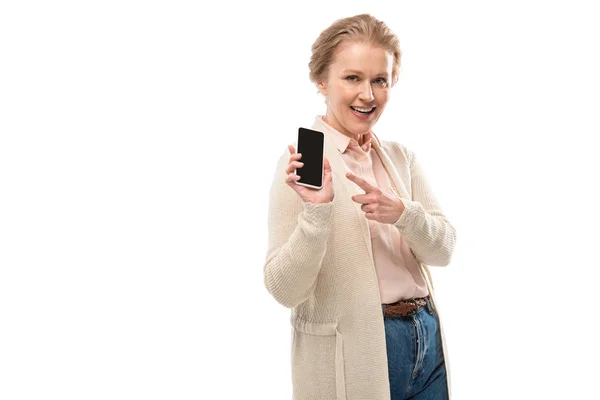 Heureuse femme d'âge moyen pointant du doigt le smartphone avec écran vierge isolé sur blanc — Photo de stock