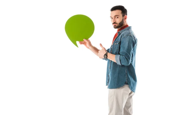 Hombre serio sosteniendo la burbuja del pensamiento y mostrando el pulgar hacia arriba aislado en blanco - foto de stock