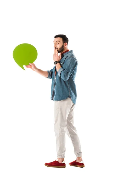 Hombre guapo sorprendido con la burbuja del pensamiento cogida de la mano cerca de la boca aislada en blanco - foto de stock