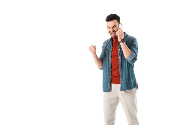 Irritado hombre peleando y mostrando el puño mientras habla en el teléfono inteligente aislado en blanco - foto de stock