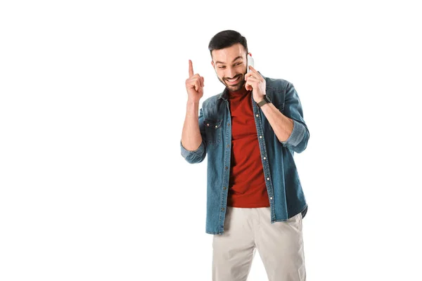 Homem alegre mostrando sinal ideia enquanto fala no smartphone isolado no branco — Fotografia de Stock