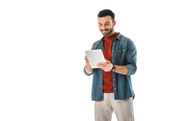 Homme barbu gai en chemise en denim en utilisant une tablette numérique isolé sur blanc — Photo de stock