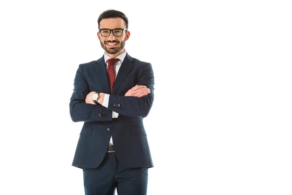 Uomo d'affari sorridente in piedi con le braccia incrociate e guardando la fotocamera isolata su bianco — Foto stock