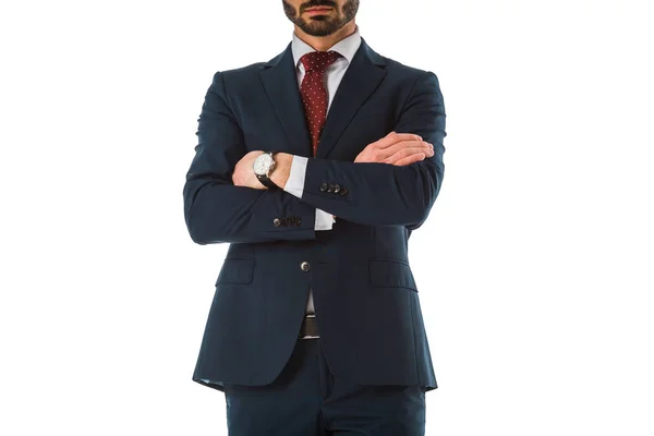 Vista recortada de hombre de negocios en traje negro de pie con brazos cruzados aislados en blanco - foto de stock