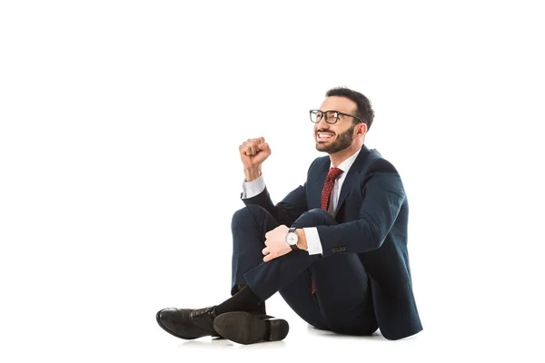 Alegre hombre de negocios mostrando sí gesto mientras está sentado sobre fondo blanco - foto de stock