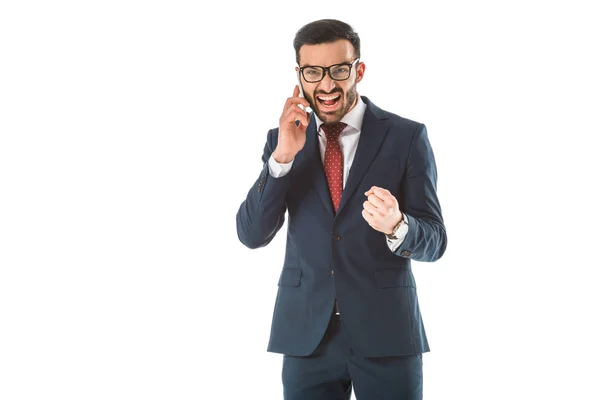 Hombre de negocios enojado gritando y mostrando el puño mientras habla en un teléfono inteligente aislado en blanco - foto de stock