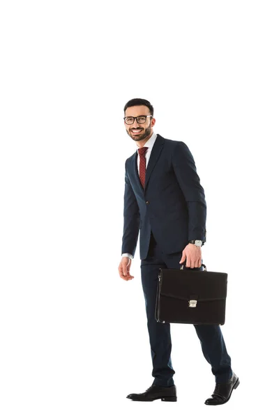 Счастливый красивый бизнесмен с портфелем улыбаясь и глядя на камеру изолированы на белом — стоковое фото