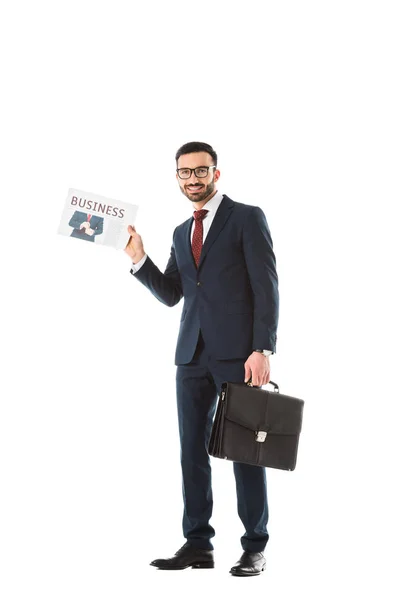 Sonriente hombre de negocios con maletín sosteniendo periódico de negocios aislado en blanco - foto de stock