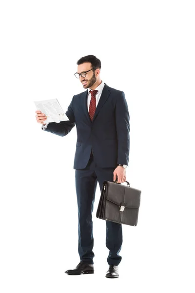 Alegre hombre de negocios con maletín leyendo periódico aislado en blanco - foto de stock