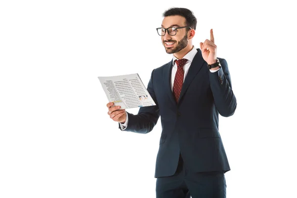 Sonriente empresario sosteniendo periódico y mostrando idea signo aislado en blanco - foto de stock