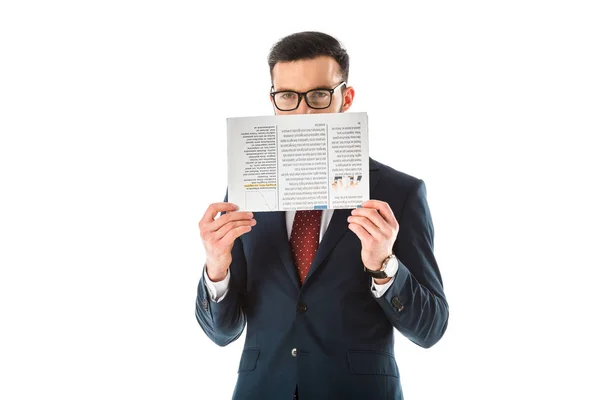 Businessman in black suit and glasses hiding face behind newspaper and looking at camera isolated on white — Stock Photo