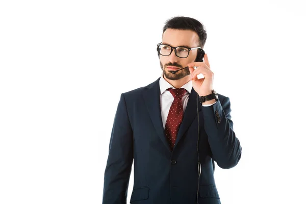 Seriöser Call-Center-Betreiber im schwarzen Anzug mit Headset und isoliertem Blick auf weiß — Stockfoto