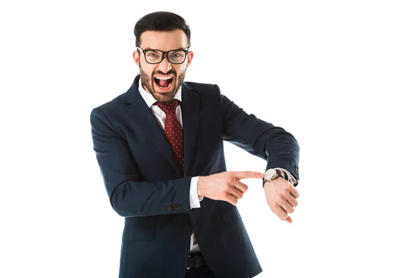 Angry businessman quarreling while looking at camera and pointing at watch isolated on white — Stock Photo