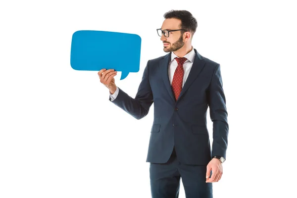 Sonriente hombre de negocios en traje negro mirando la burbuja del habla aislada en blanco - foto de stock