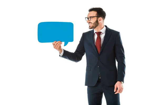Cheerful handsome businessman in black suit holding speech bubble isolated on white — Stock Photo